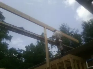 Carpenter setting a ridge beam over a new addition frame — Ice Dam Removal by Roofing Brothers in Poughquag