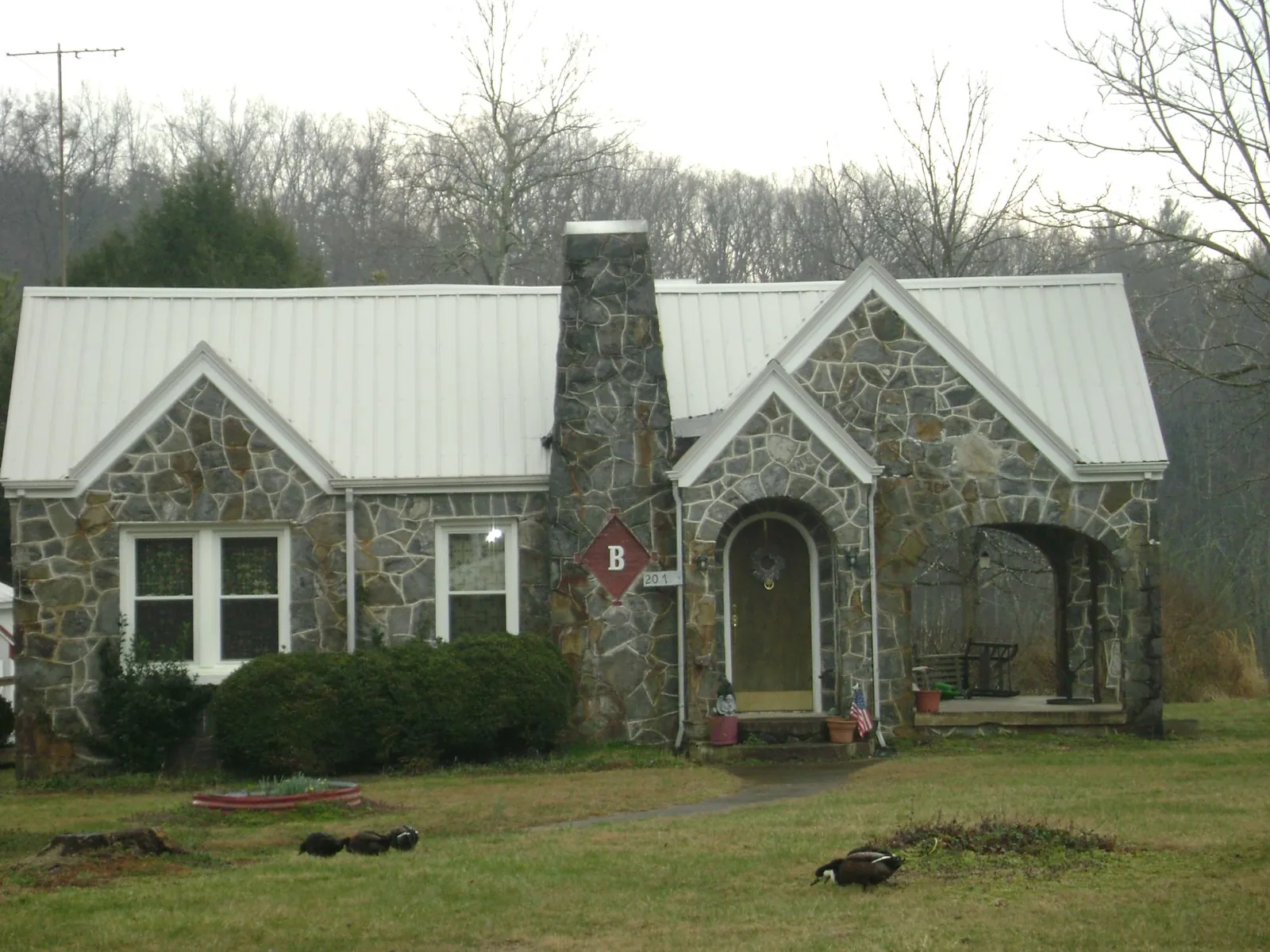 White metal roof on a stone cottage with steep gables in Poughquag