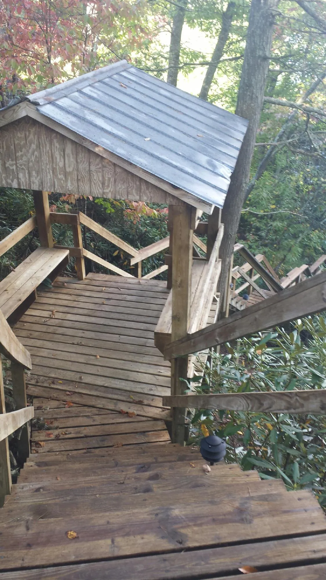Metal roofed shelter over wooden steps on a wooded walkway — Skylight Repair & Installation work by our crew in Poughquag
