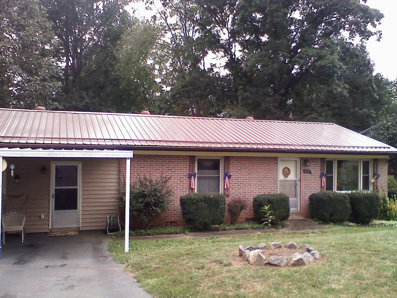 Bronze metal roof and carport on a brick ranch home — Roof Repair work by our crew in Poughquag
